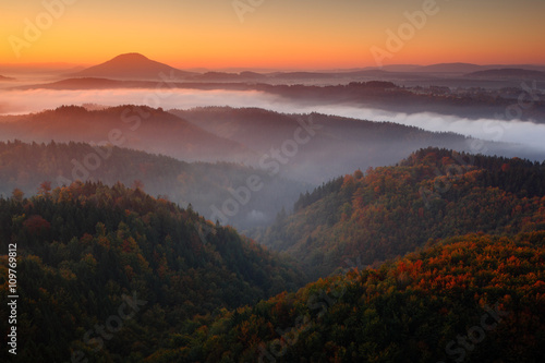Cold misty foggy morning with sunrise in a fall valley of Bohemian Switzerland park. Hills with fog, landscape of Czech Republic, beautiful national park Ceske Svycarsko