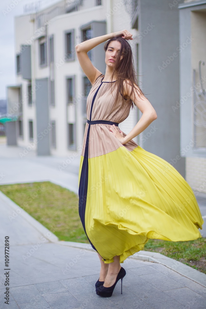 Beautiful brunette in a dress on the street. Beautiful brunette in a dress on the street.