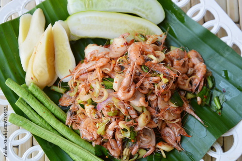 prawn spicy salad with herb on fresh banana leaf photo