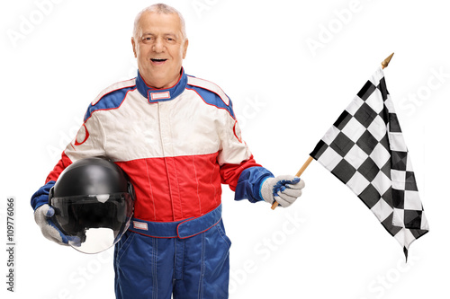 Mature man in a racing uniform holding a checkered race flag isolated on white background