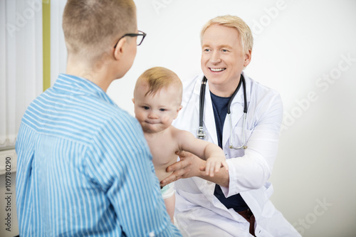Doctor Holding Baby While Looking At Woman