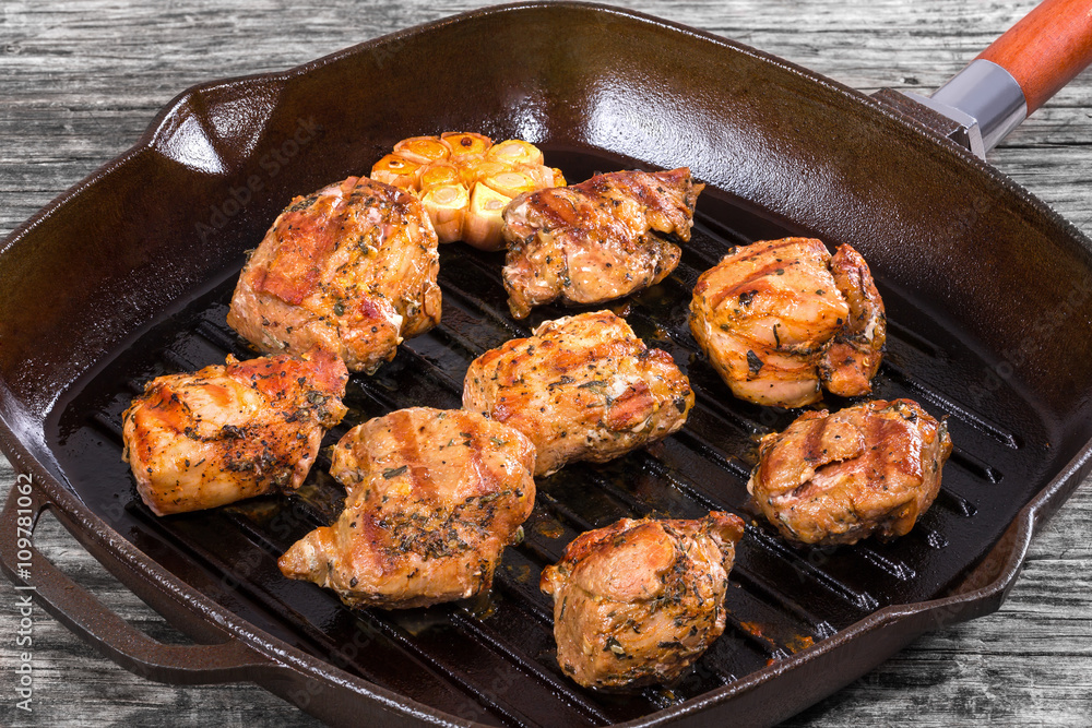 pieces of grilled meat on a skillet, close-up