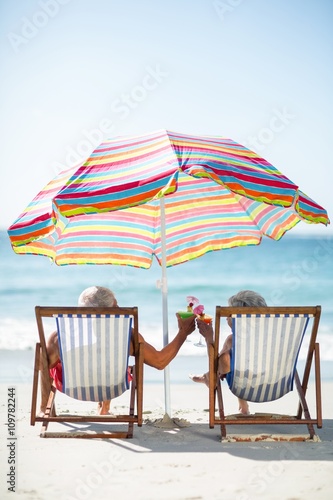 Fotografie Cute mature couple lying on deckchairs