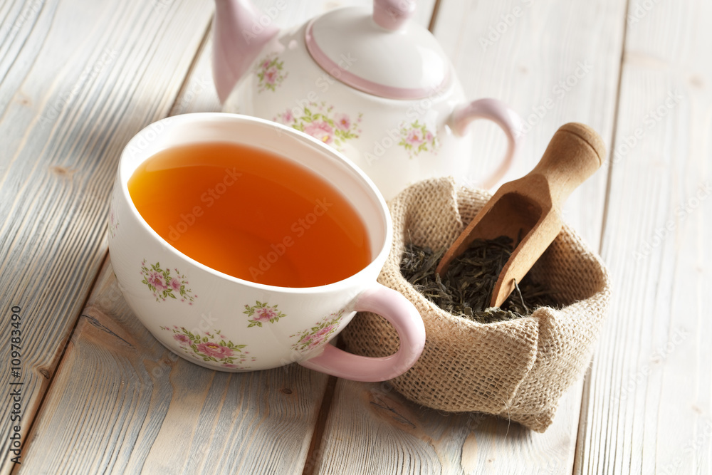 Cup of tea and teapot and dried leaves of tea Cup of tea and teapot and dried leaves of tea