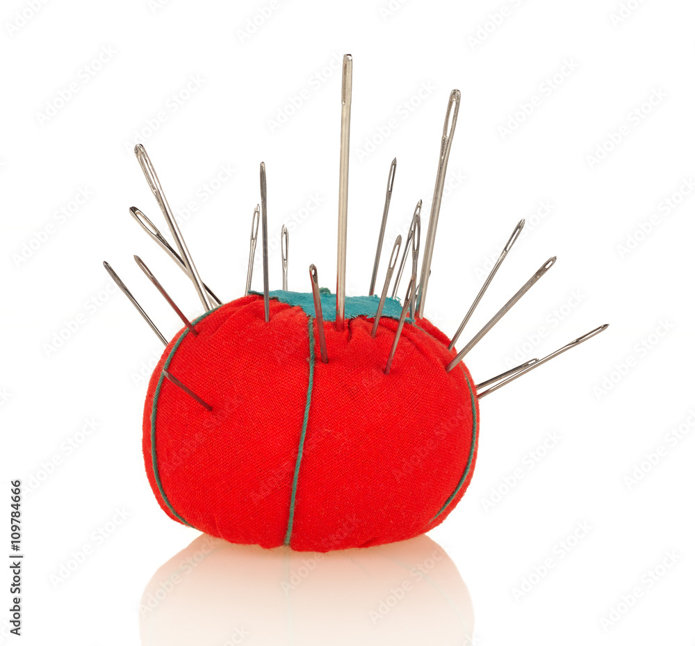 Steel sewing needles in red pincushion isolated on white Steel sewing needles in red pincushion isolated on white
