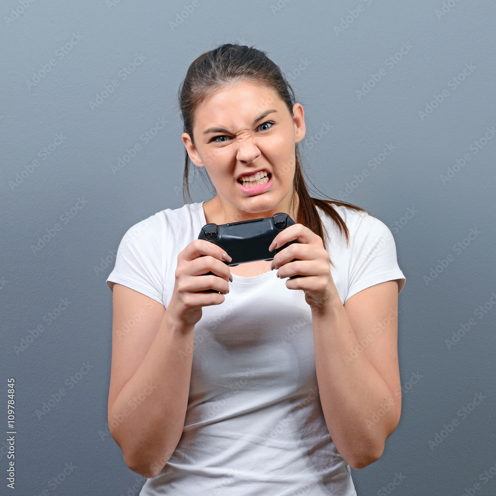 Portrait of woman playing video games against gray background Portrait of woman playing video games against gray background