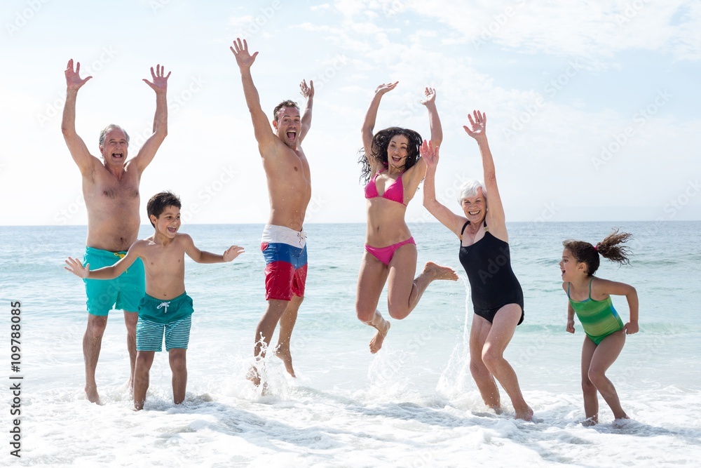 Happy multi genration family jumping at beach Happy multi genration family jumping at beach