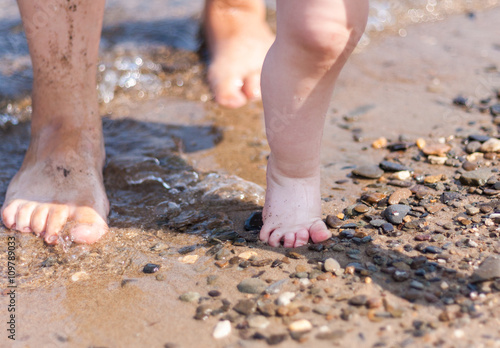 Mother and child feet on a sandy beach