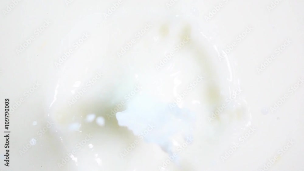 Fresh red strawberry with green-grass top dropping into the white milk with stunning splash. Shot on high-speed camera in slow motion mode. Fresh red strawberry with green-grass top dropping into the white milk with stunning splash. Shot on high-speed camera in slow motion mode.