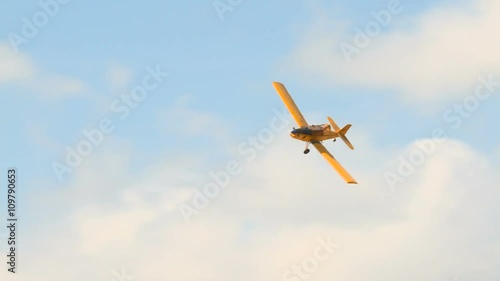 Yellow crop duster. Agricultural aircraft. Aircraft, airplane flying in a blue sky with clouds before splashing. sprays chemicals against pests . Shooting from the front.