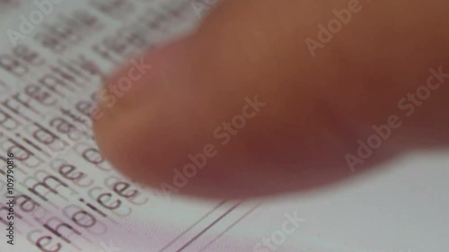 Ultra macro close up of a user scrolling through an online voting app on a tablet or smartphone, then tapping a button which reads 'Vote Now'; shot at pixel level photo