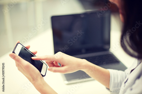 close up of woman texting on smartphone at office