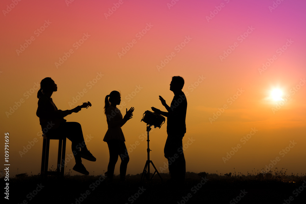 musician playing guitar against the background of sunset