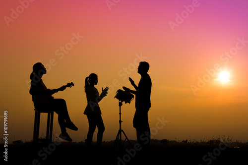 musician playing guitar against the background of sunset