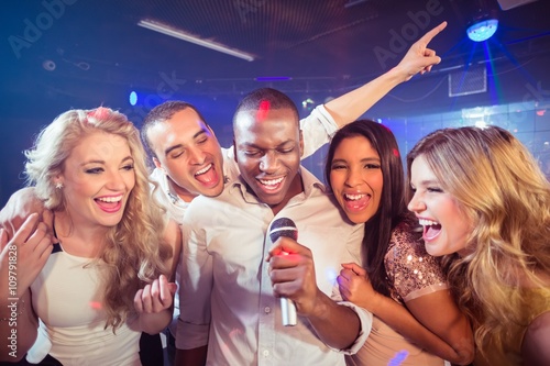  Happy friends singing at the karaoke photo