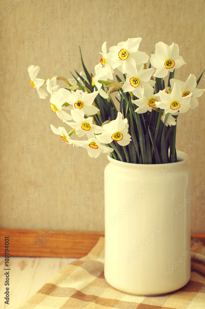 Narcissus flowers bouquet in the white vase in vintage style