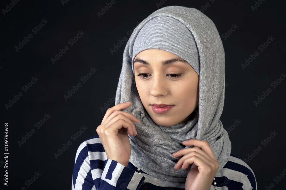studio portrait of a beautiful young woman of Middle Eastern type, in an unusual scarf on her head, on a dark background studio portrait of a beautiful young woman of Middle Eastern type, in an unusual scarf on her head, on a dark background