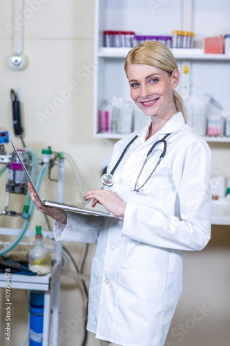 Portrait of woman vet using her laptop
