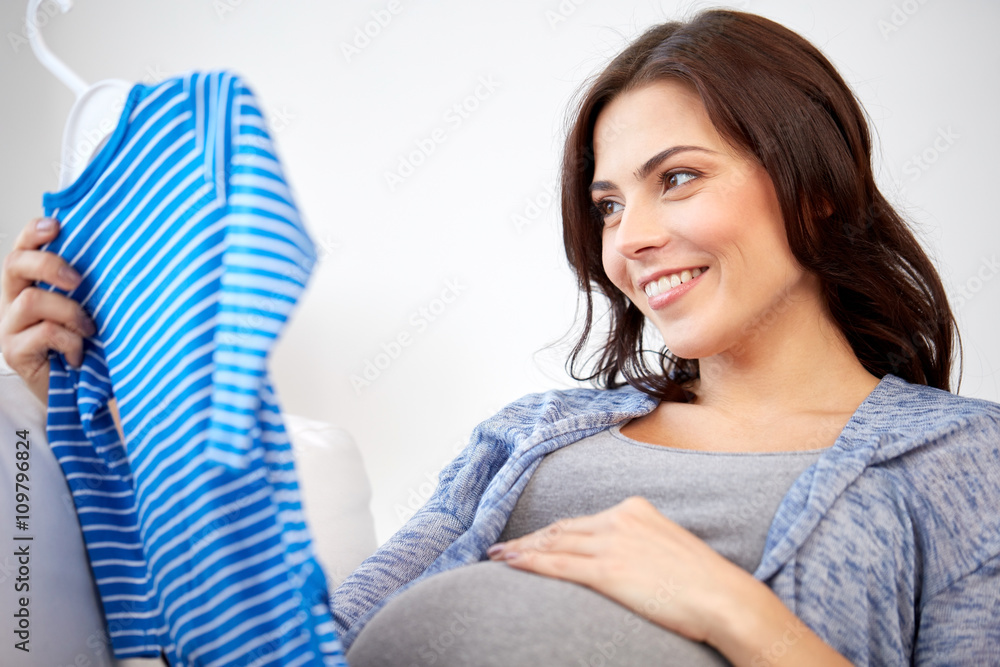 happy woman holding baby boys bodysuit at home happy woman holding baby boys bodysuit at home