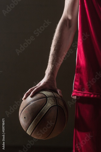 Close up on basketball held by basketball player © WavebreakMediaMicro