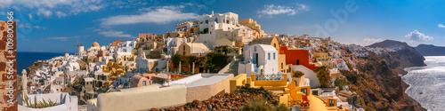 Picturesque panorama, Old Town of Oia or Ia on the island Santorini, white houses, windmilles and church with blue domes, Greece