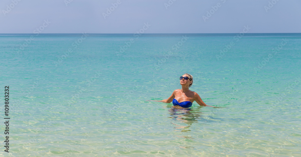 Young slim blonde swimming in the sea