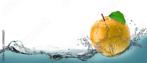 Fotografie Yellow, juicy apple as a card on the water background.