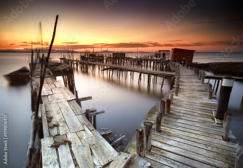 Ancient fishing pier with warm and beautiful sunset photo