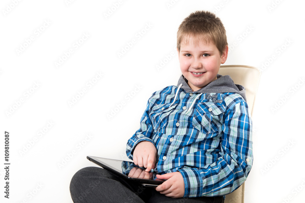 Smiling child holding tablet PC in hands. Idea concept. Photo shoot in the studio boy with tablet and a bulb-to-day knowledge Smiling child holding tablet PC in hands. Idea concept. Photo shoot in the studio boy with tablet and a bulb-to-day knowledge