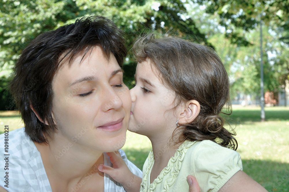Daughter kissing her lovely and happy mother Daughter kissing her lovely and happy mother