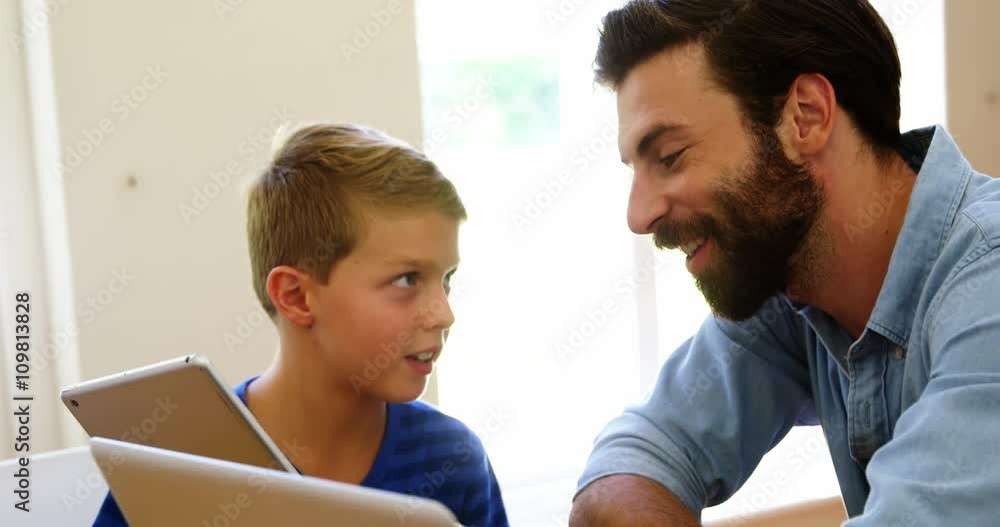 Father and son looking tablet together Father and son looking tablet together