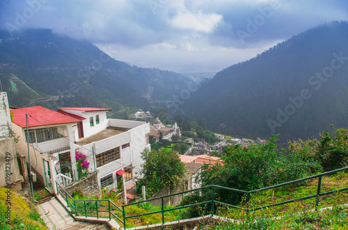 Charming village of Guapulo in Quito Ecuador with houses built downward valley, spectacular view Andes mountains