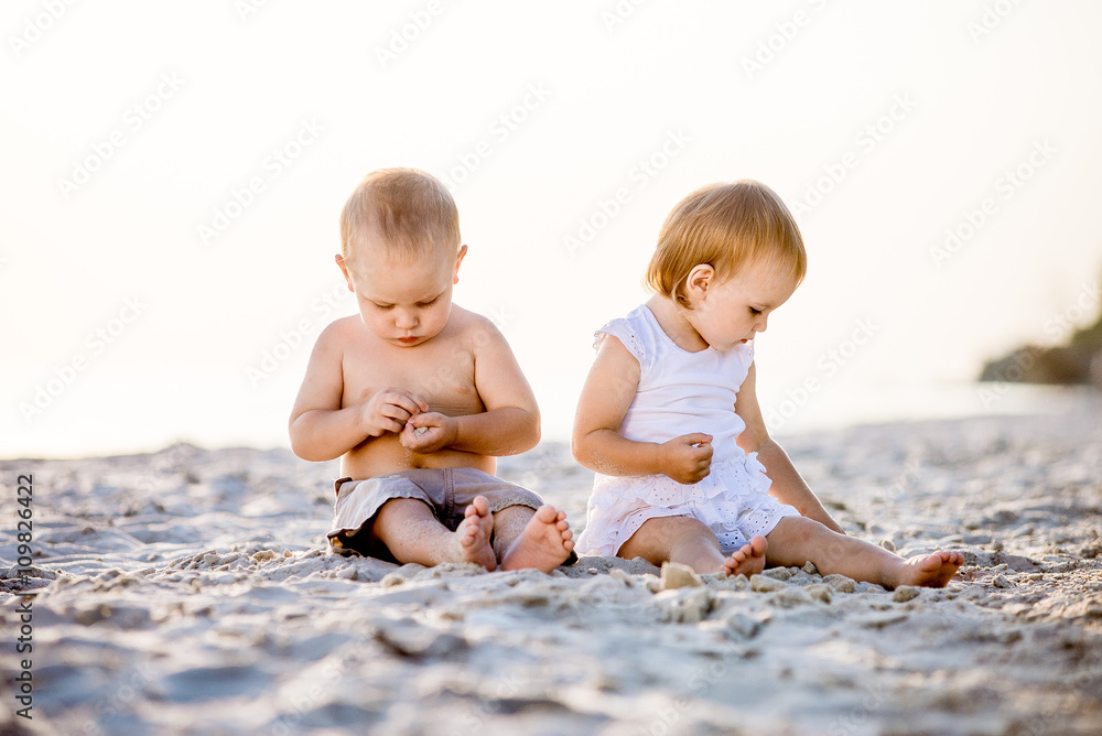 young children walking on the beach in summer young children walking on the beach in summer