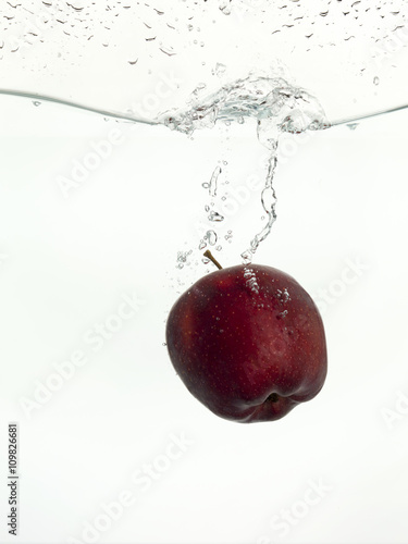 fresh red apple sinking on water