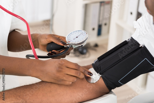 фотографія Doctor Measuring Patients Blood Pressure