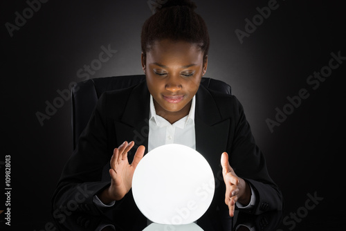 Young Businesswoman Predicting Future With Crystal Ball