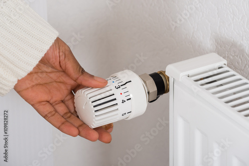 Person's Hand Adjusting Radiator Temperature