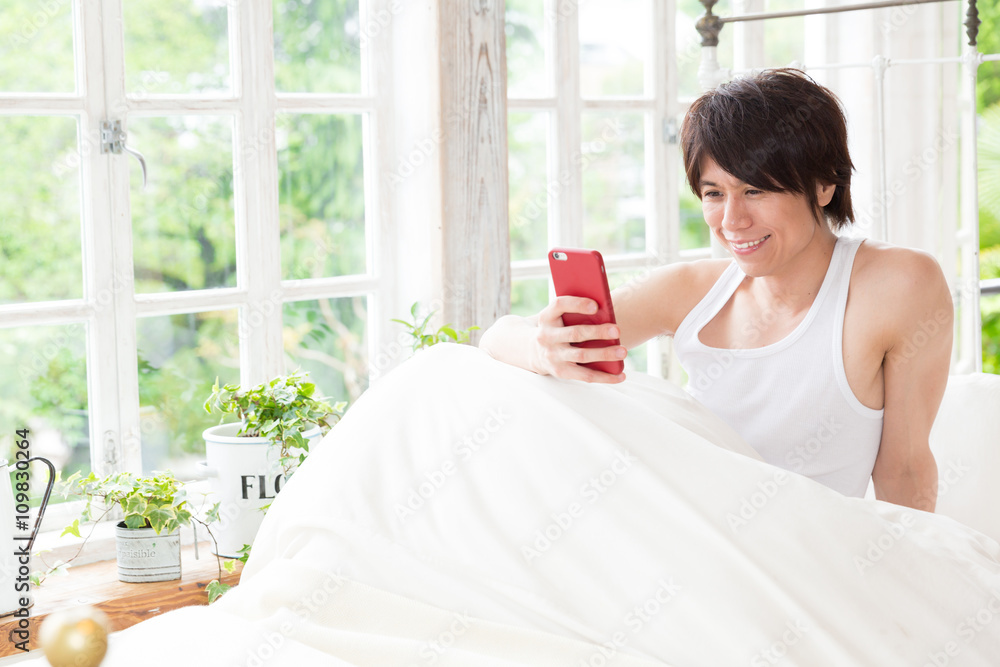 portrait of young asian man using smart phone in the bed portrait of young asian man using smart phone in the bed