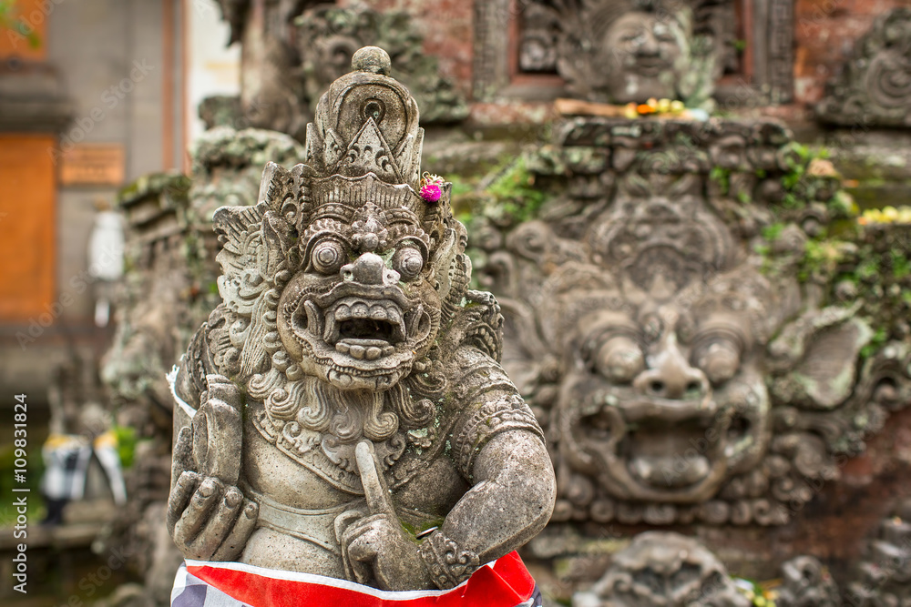 Fototapeta premium Traditional demon guard statue carved in stone on Bali island, Indonesia.