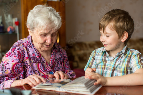 Grandmother and grandson looking photo album.