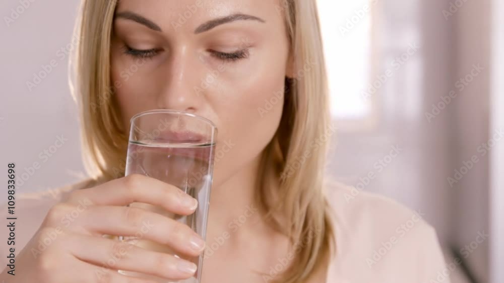 Close up on a woman drinking a glass of water Close up on a woman drinking a glass of water