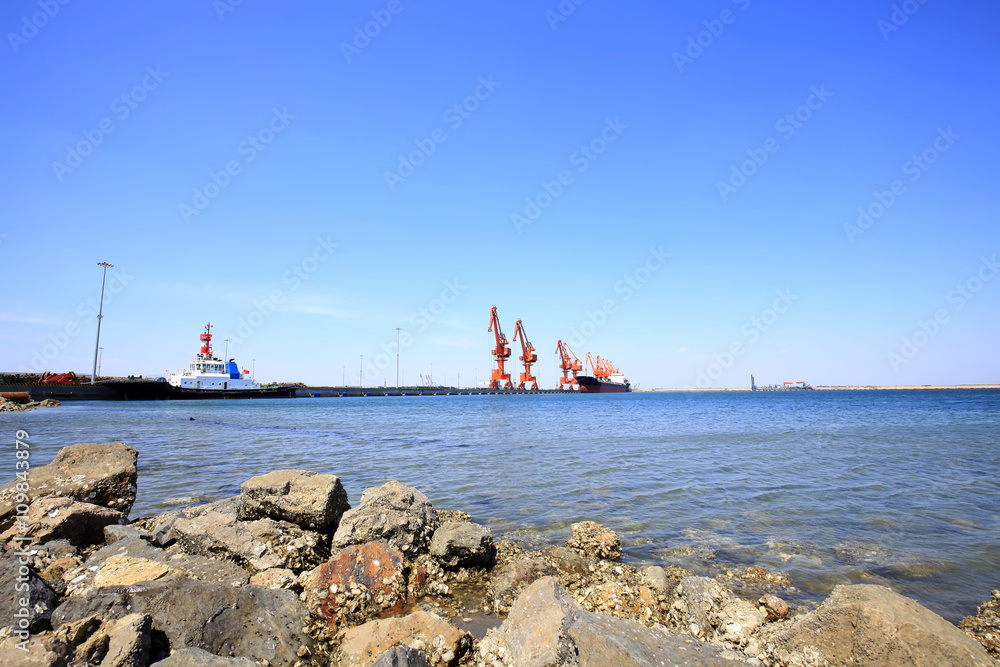 In freight terminal, gantry crane and cargo ships are in loading In freight terminal, gantry crane and cargo ships are in loading