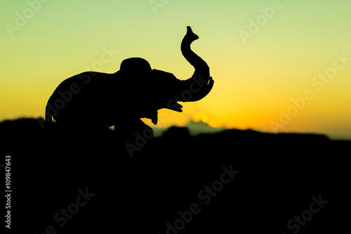 Silhouette of elephant at river sunset background