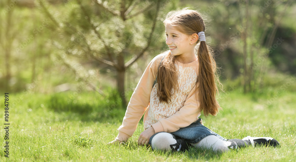cute smiling little girl sitting on the grass cute smiling little girl sitting on the grass