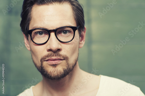 Spectacles on handsome man in studio, portrait photo