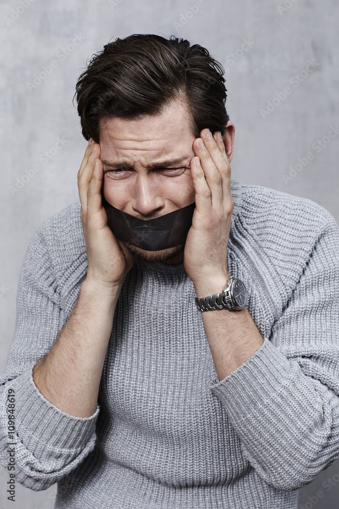 Frustrated guy with tape over mouth Stock Photo Adobe Stock