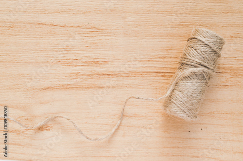 Old scissors and skein jute twine on a wooden background, selective focus, rustic style.