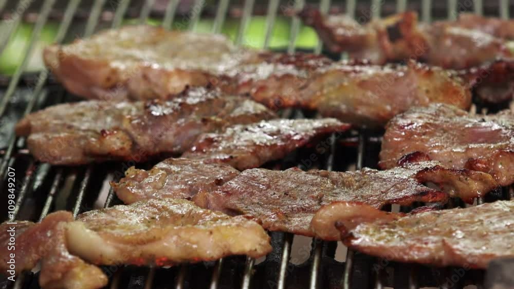 Grilling pork chops on barbecue, tiny juicy meat slices roasting on bbq grid plate Grilling pork chops on barbecue, tiny juicy meat slices roasting on bbq grid plate
