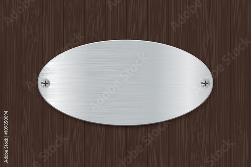 Oval metal plate on wooden background.