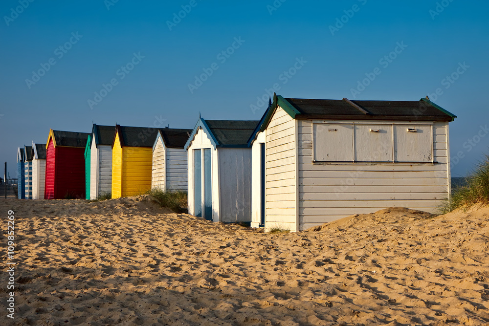 A row of brightly coloured beach huts in Southwold Suffolk A row of brightly coloured beach huts in Southwold Suffolk